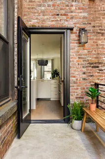 a view of a patio with table and chairs potted plants and a house