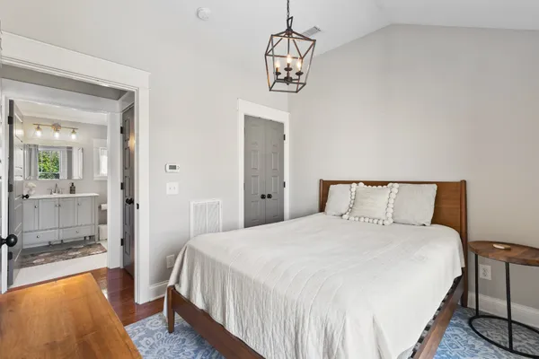 a bedroom with a bed and a chandelier