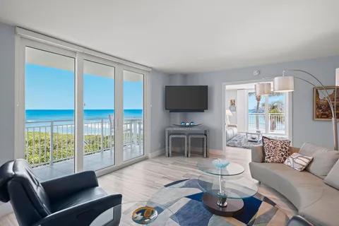 a living room with furniture a flat screen tv and a large window