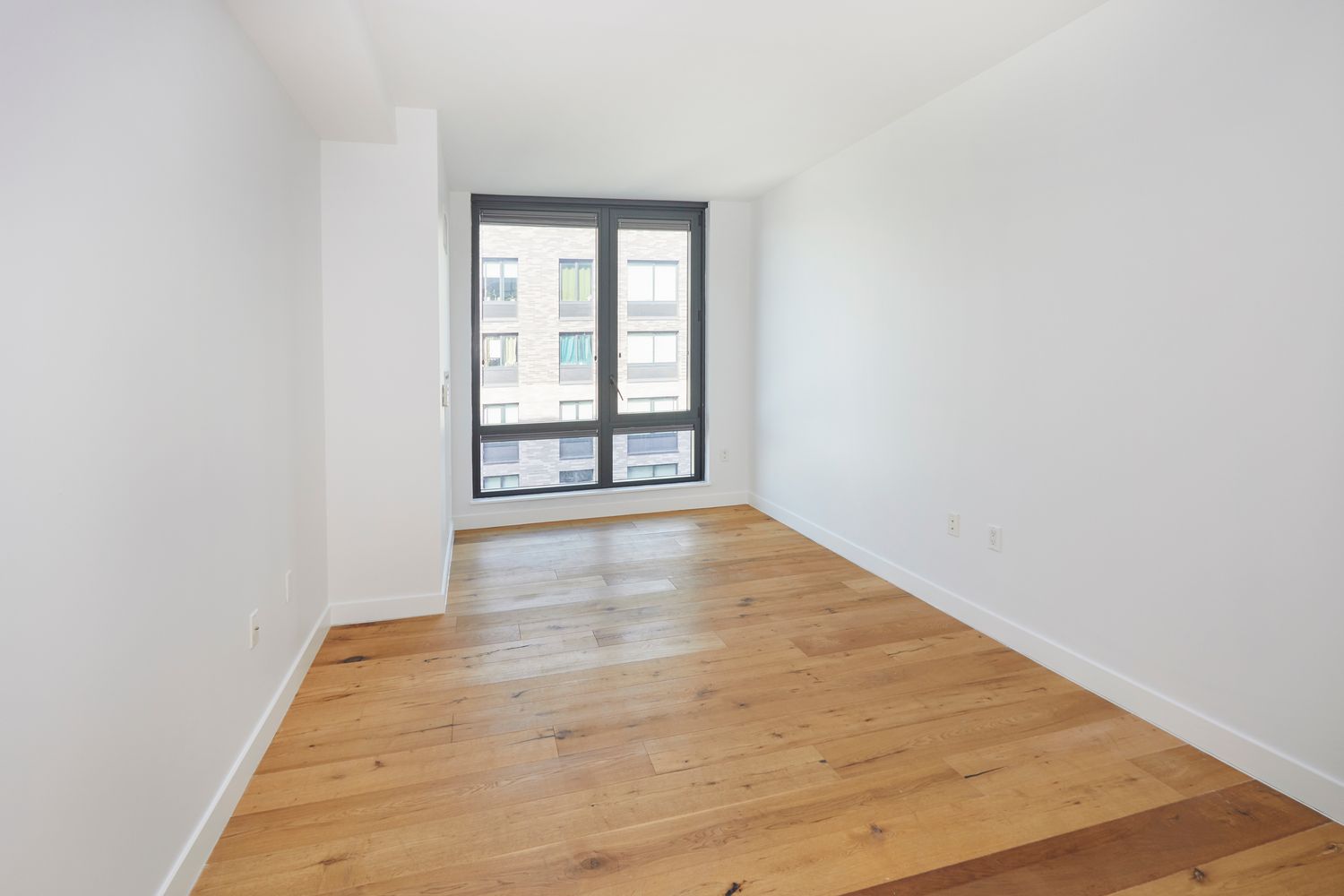 23 West 116th Street, Unit 8A Manhattan, NY 10026 - Photo 15 of 28 an empty room with wooden floor and windows