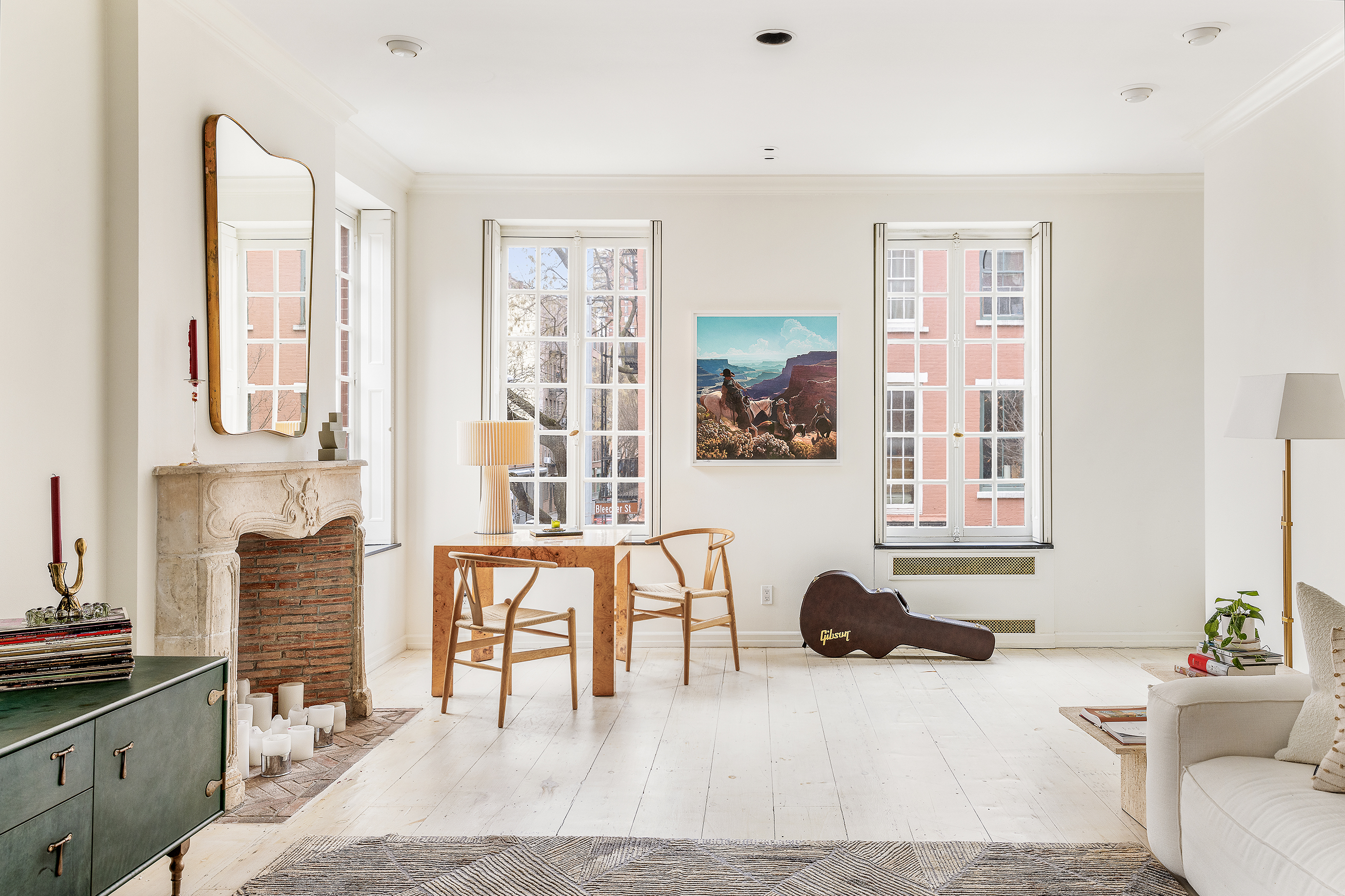 a living room filled with furniture a fireplace and next to a window
