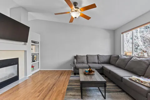 a living room with furniture a flat screen tv and a fireplace