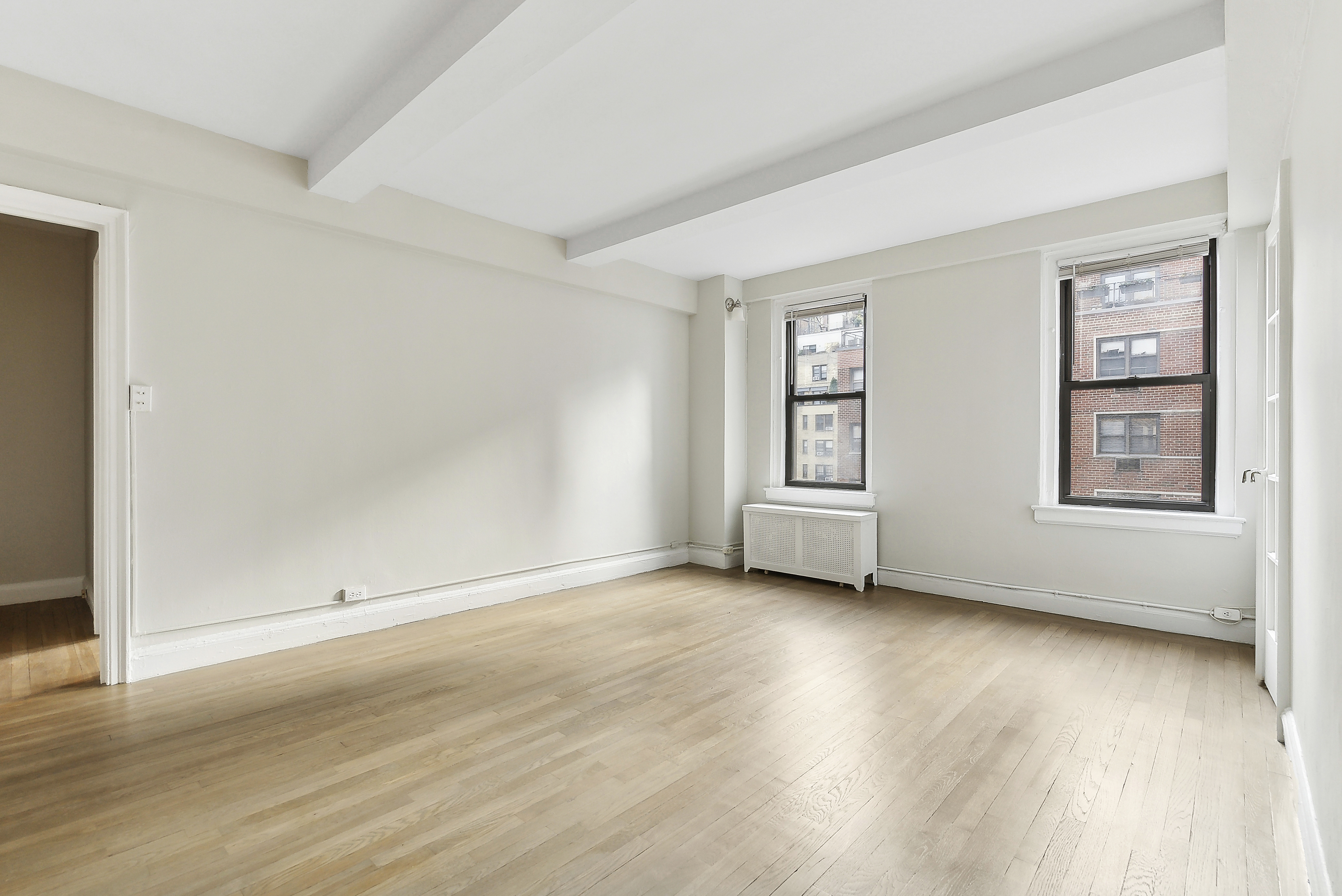 321 East 54th Street, Unit 9B Manhattan, NY 10022 - Photo 2 of 13 a view of an empty room with window and wooden floor