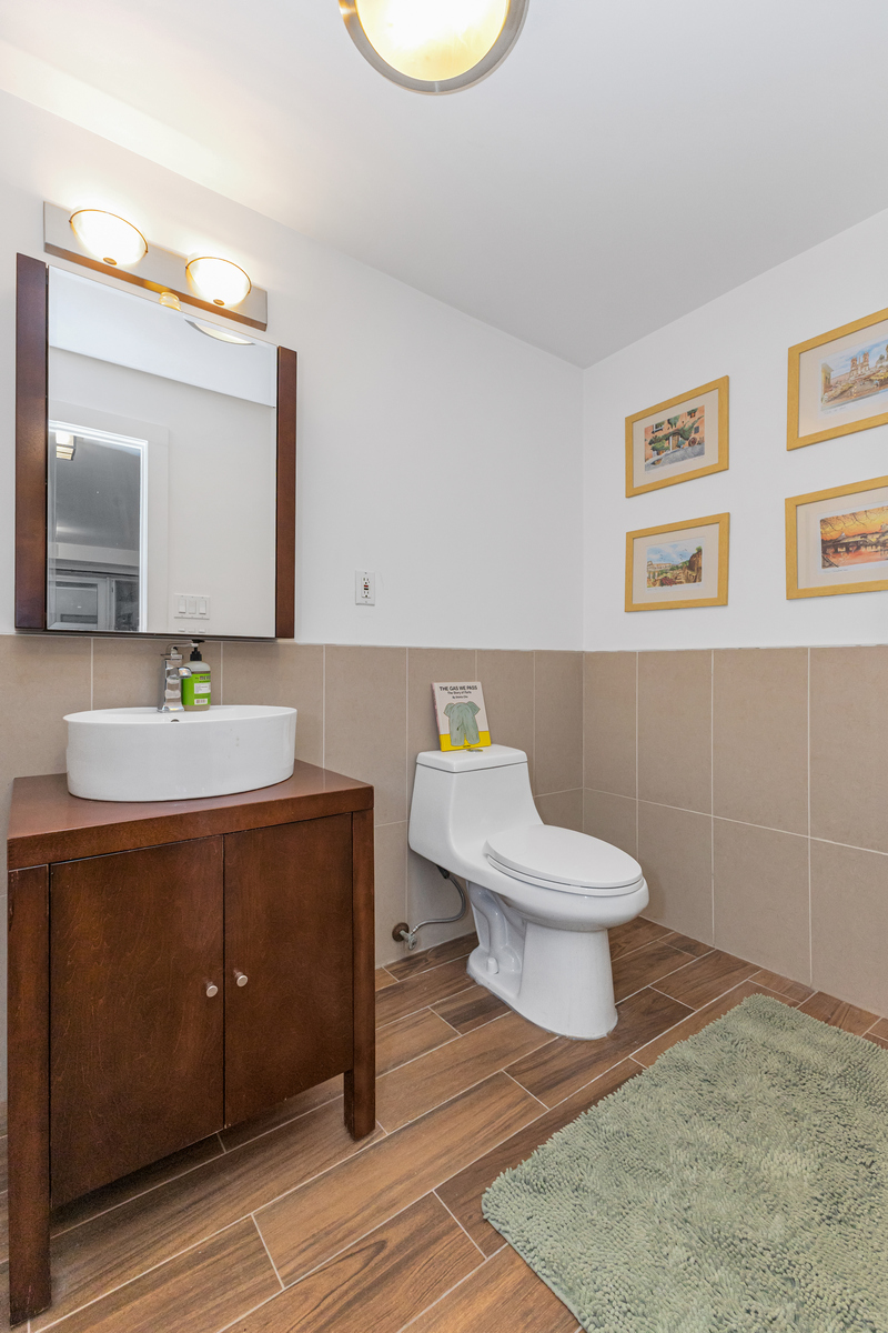 319 Humboldt Street, Unit 1B Brooklyn, NY 11211 - Photo 12 of 17 a bathroom with a toilet a sink and mirror