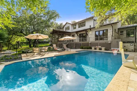a swimming pool with outdoor seating water slide and yard
