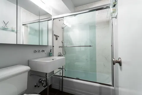 a bathroom with a sink mirror toilet and shower