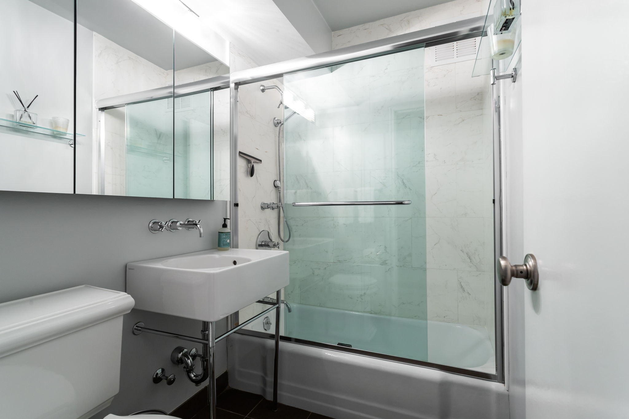 415 East 85th Street, Unit 5J Manhattan, NY 10028 - Photo 14 of 19 a bathroom with a sink mirror toilet and shower