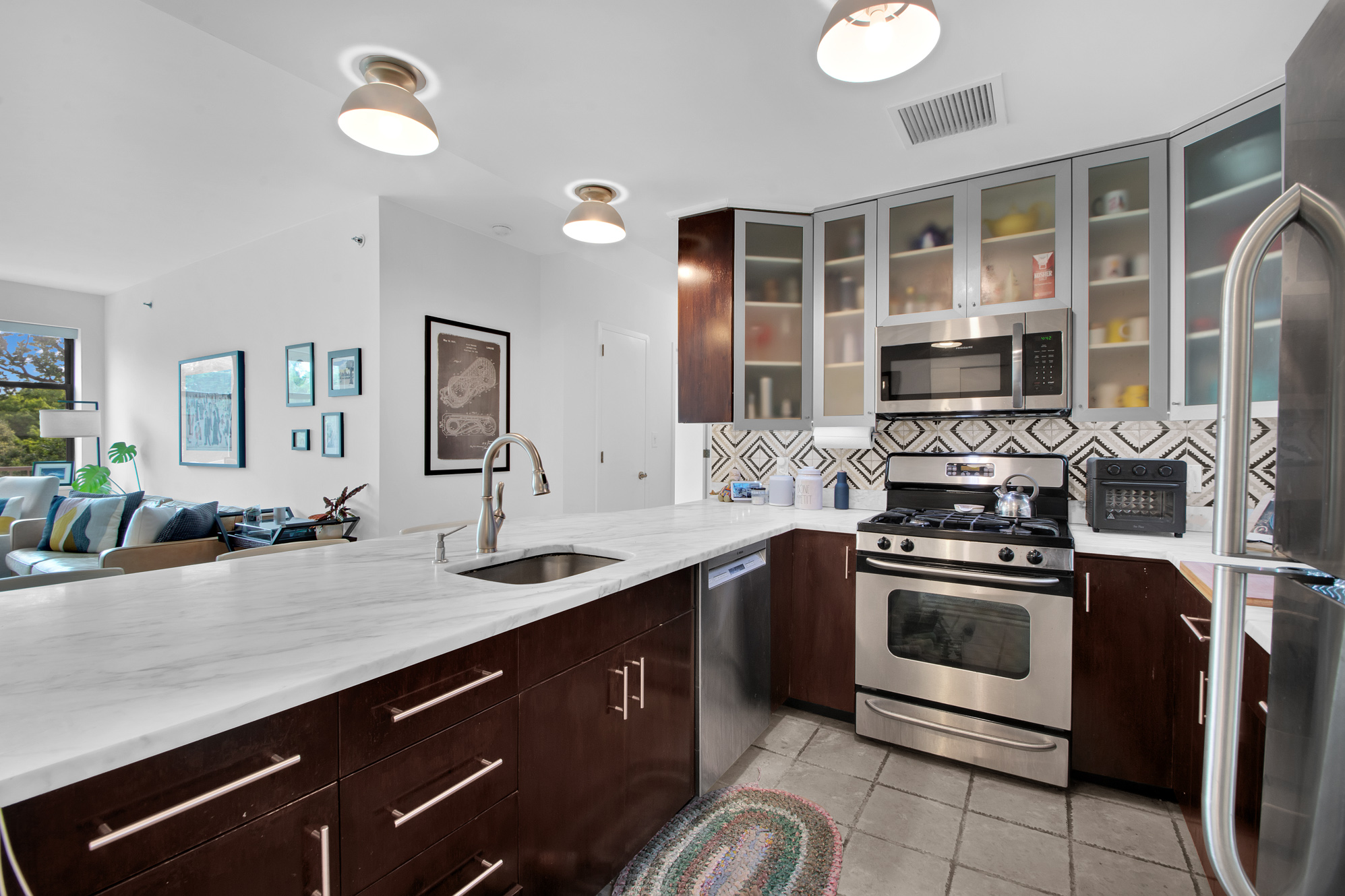 2002 5th Avenue, Unit 5B Manhattan, NY 10035 - Photo 4 of 7 a kitchen with stainless steel appliances granite countertop a sink and stove top oven