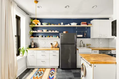 a kitchen with stainless steel appliances a white refrigerator and a stove top oven