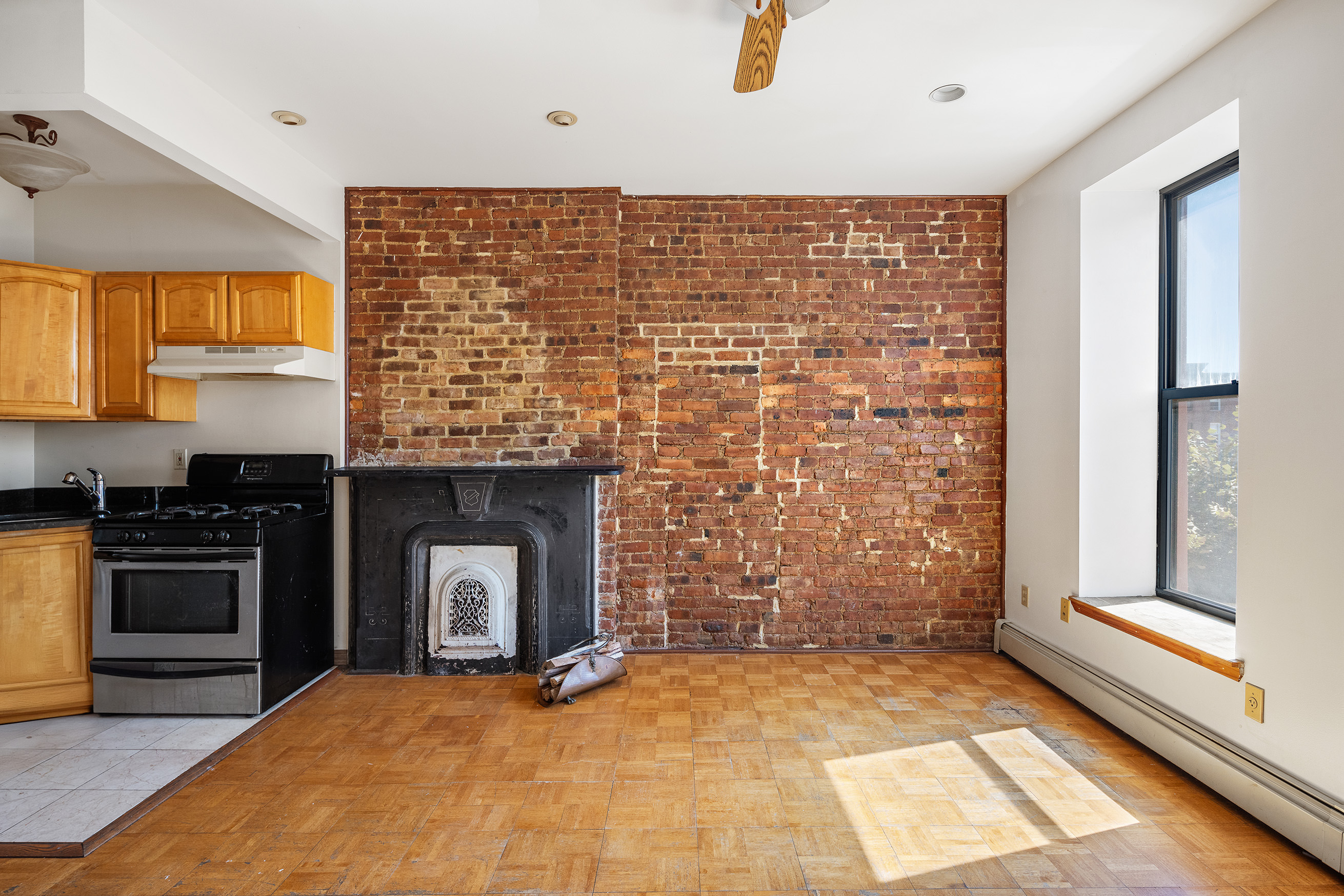 37 Quincy Street Brooklyn, NY 11238 - Photo 13 of 24 a view of an empty room with a fireplace and a window
