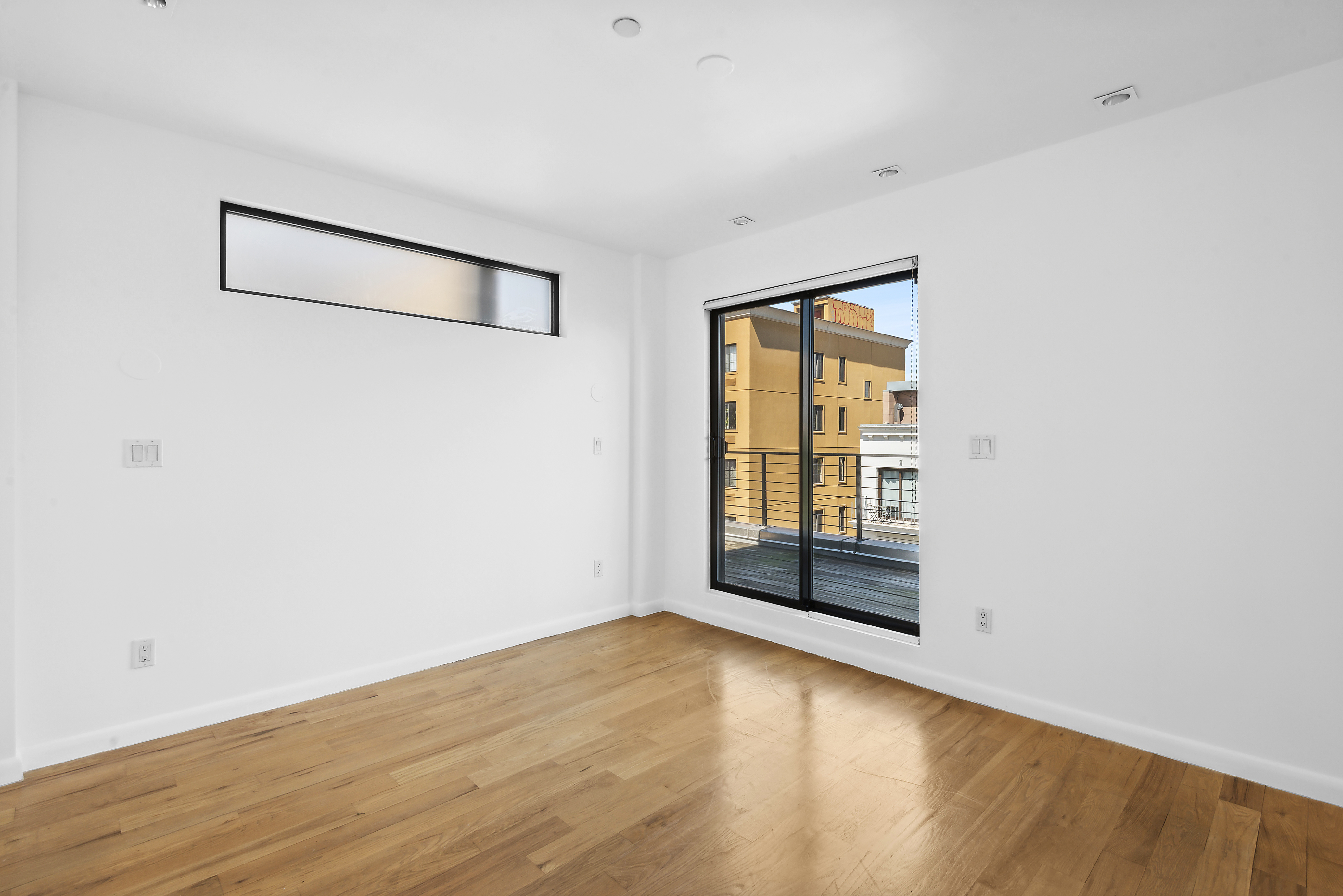 27 Dodworth Street, Unit PHF Brooklyn, NY 11221 - Photo 6 of 18 an empty room with wooden floor and windows