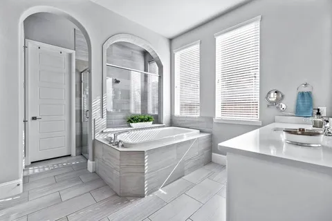 a spacious bathroom with a granite countertop tub sink and mirror