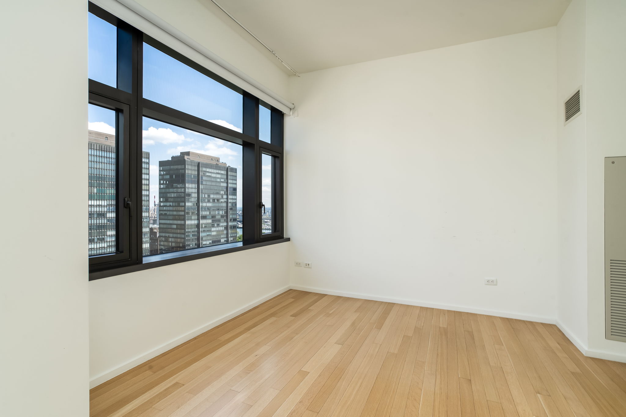 50 United Nations Plaza, Unit 26B Manhattan, NY 10017 - Photo 21 of 25 a view of an empty room with wooden floor and a window