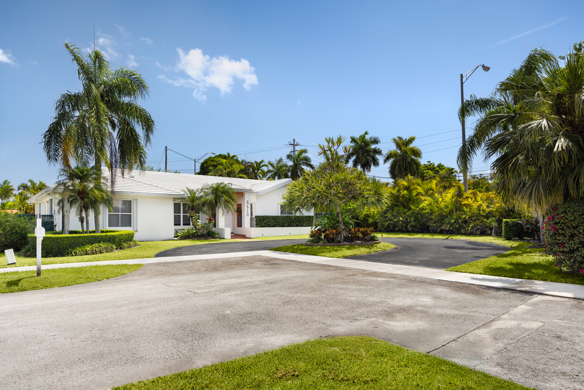 8610 Southwest 83rd Street Miami, FL 33143 - Photo 42 of 46 a front view of a house with a yard and palm trees