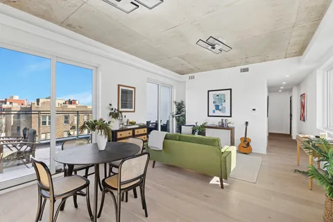 a living room with furniture a chandelier and a dining table