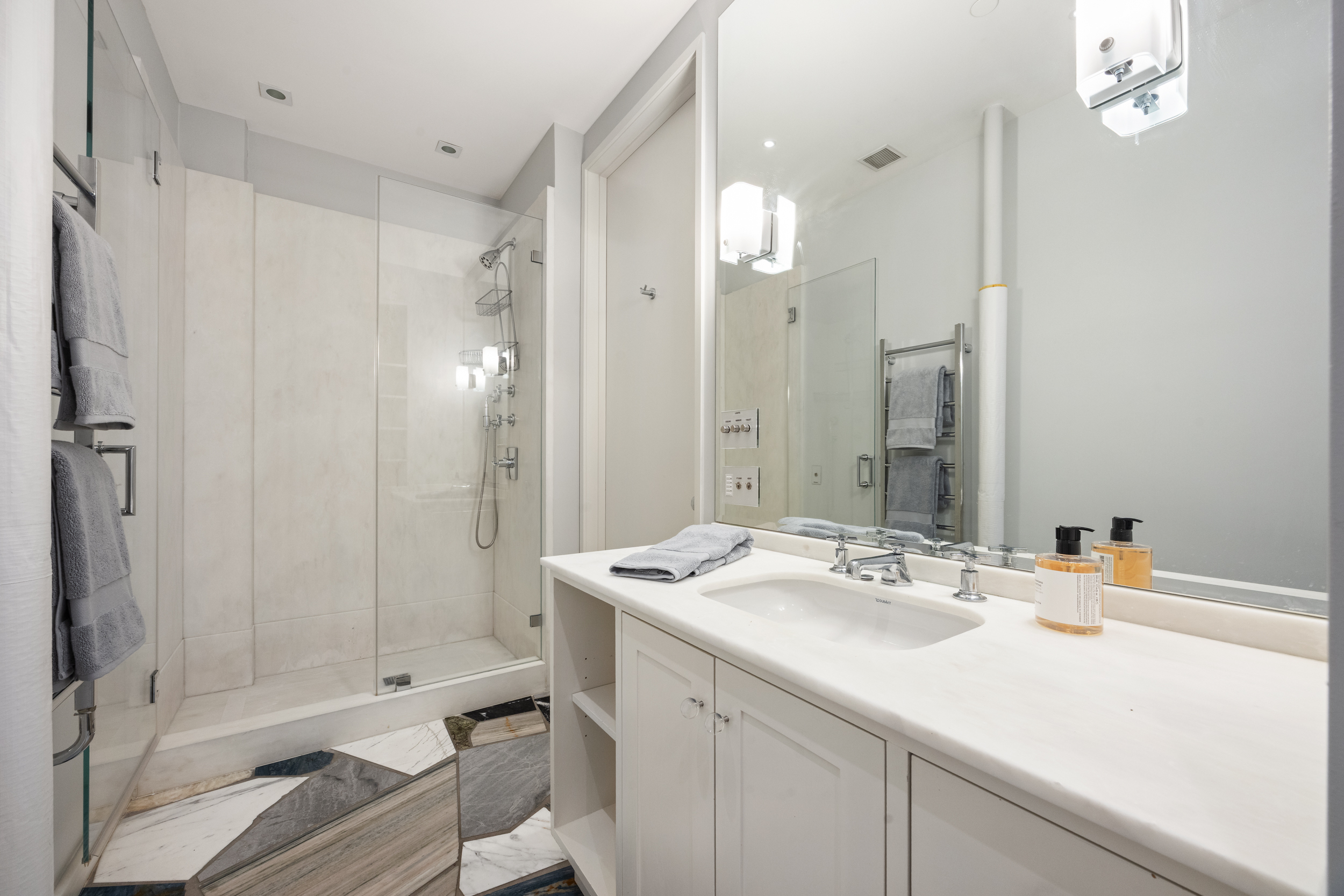 32 West 20th Street, Unit 5 Manhattan, NY 10011 - Photo 15 of 18 a bathroom with a sink shower and a mirror