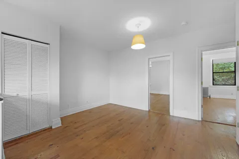 an empty room with wooden floor and window