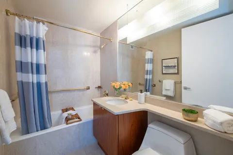 a bathroom with a sink vanity granite tub and shower