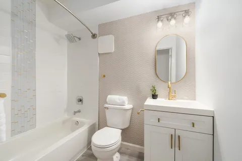 a bathroom with a toilet sink and mirror