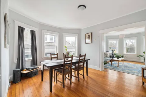 a view of a a dining room with furniture and wooden floor