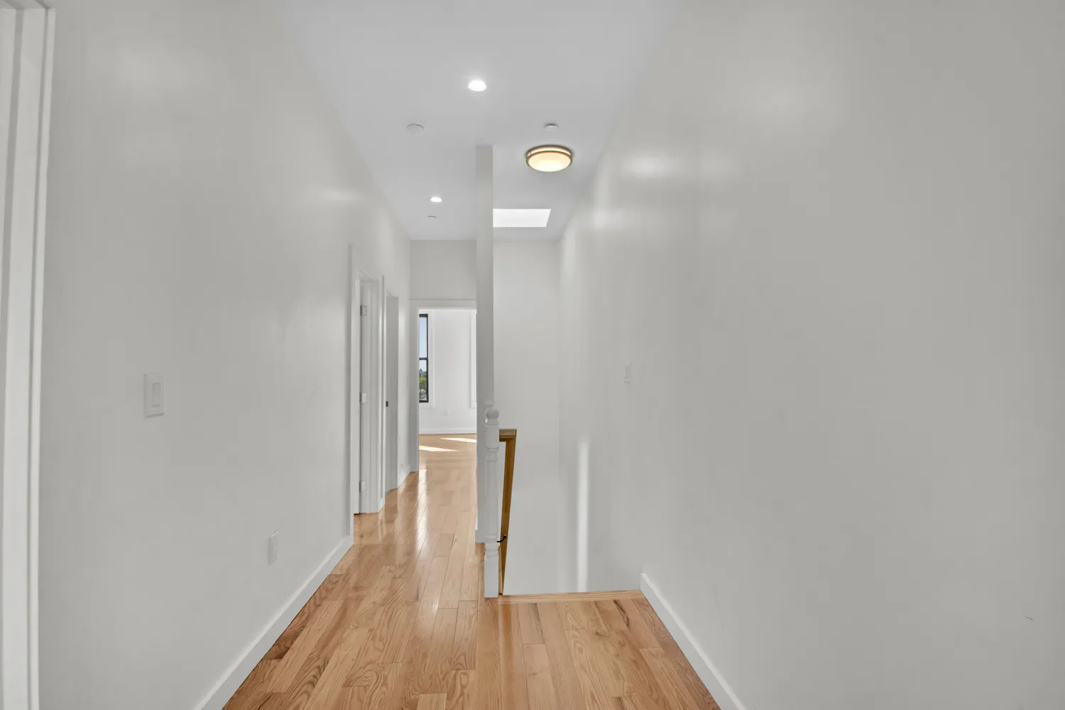 a view of a hallway with wooden floor