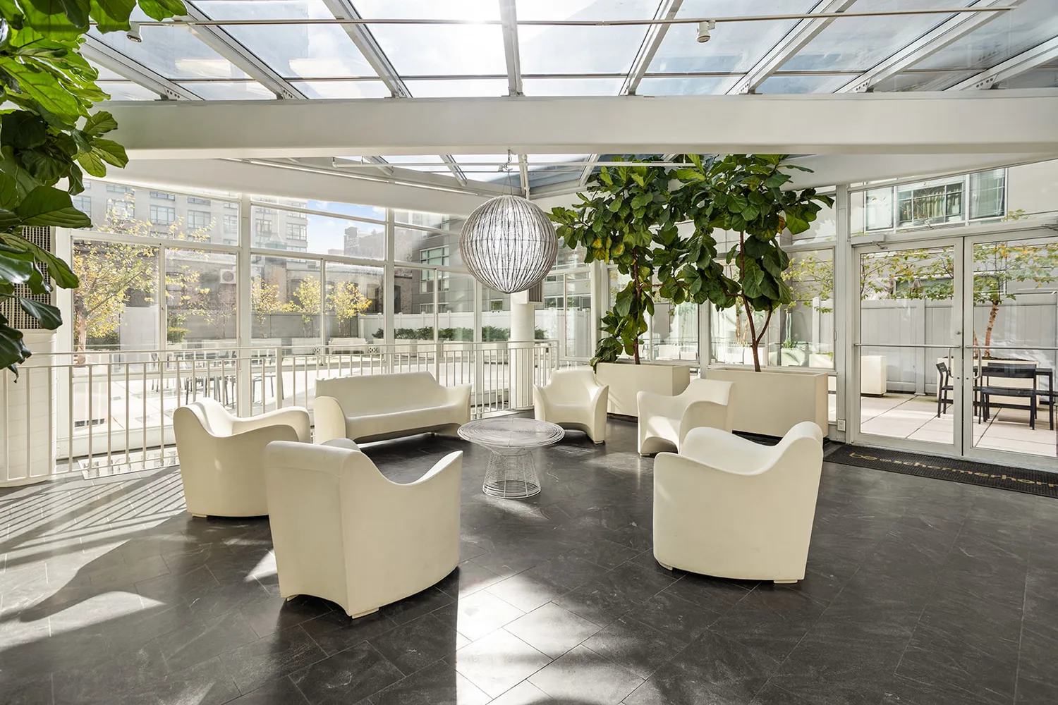 a living room with patio furniture and a potted plant