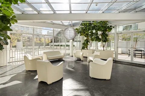 a living room with patio furniture and a potted plant