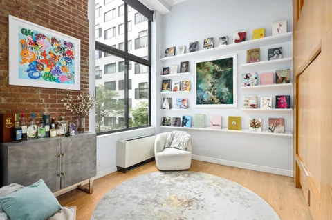 a living room with furniture and a book shelf