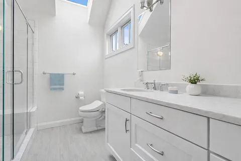 a bathroom with a sink a toilet and a mirror