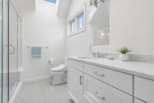 a bathroom with a sink a toilet and a mirror