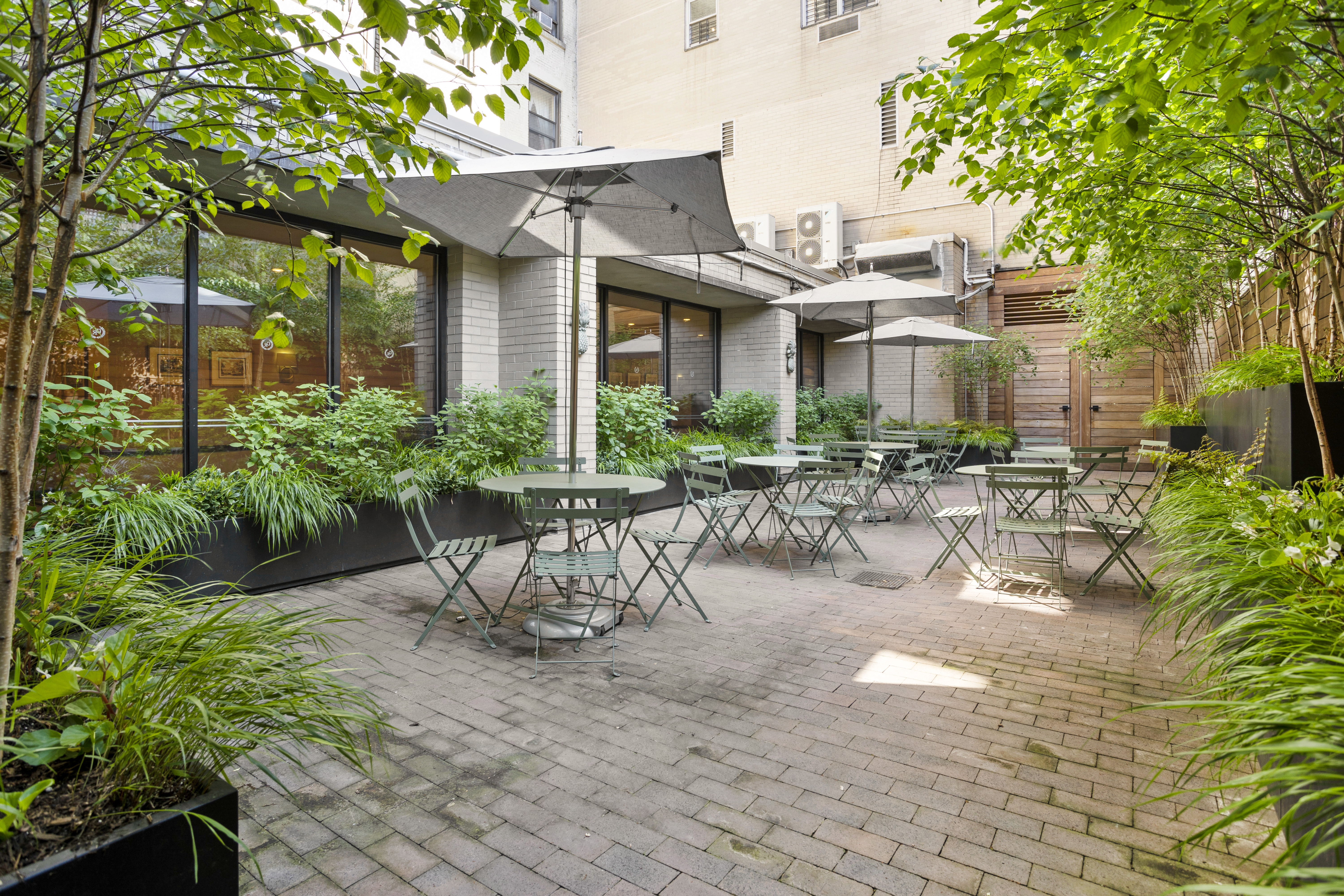 137 East 36th Street, Unit 21F Manhattan, NY 10016 - Photo 15 of 18 a view of a patio with table and chairs potted plants and large tree