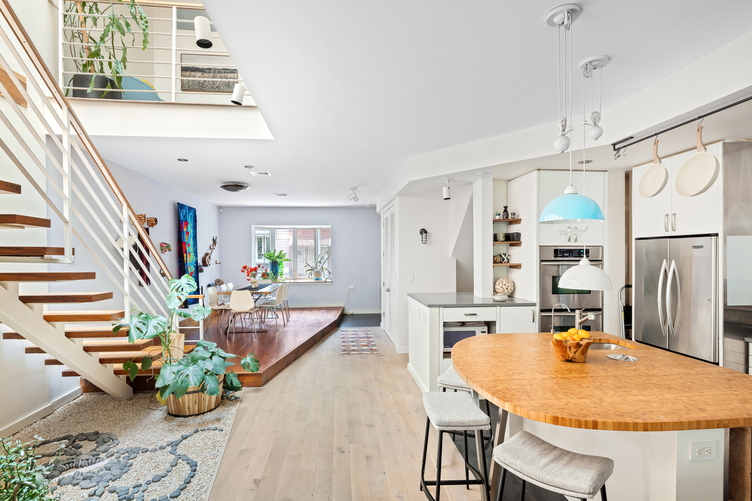 65 Jackson Street Brooklyn, NY 11211 - Photo 9 of 36 a dining room with stainless steel appliances furniture wooden floor and a chandelier