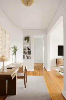 a living room with furniture a flat screen tv and a table