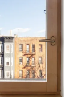 a view of a rooftop deck with chairs and wooden floor