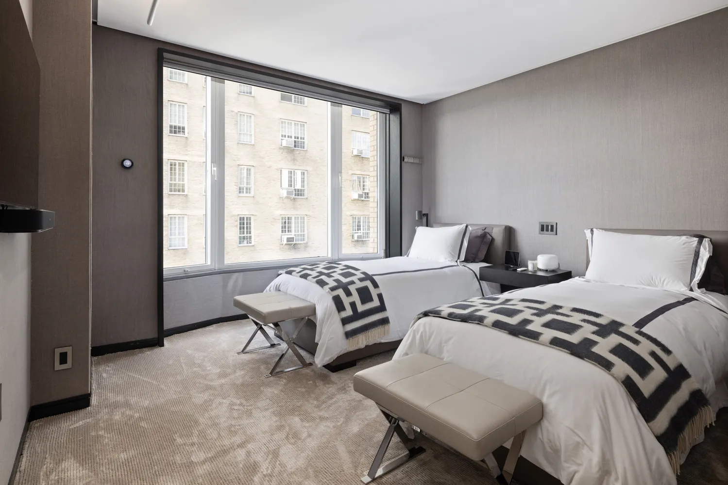 a bedroom with two beds and a large window