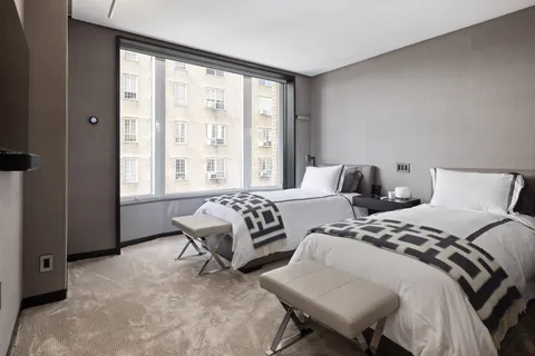 a bedroom with two beds and a large window