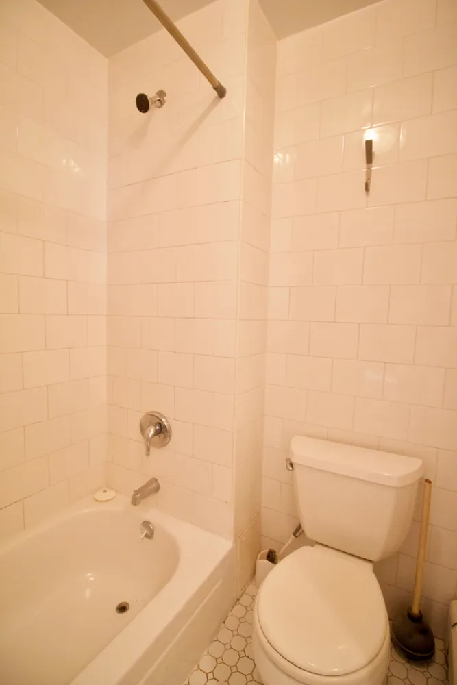 a white toilet sitting next to a bath tub and a shower