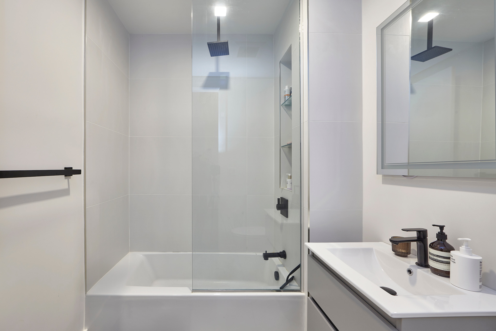 144 North 10th Street, Unit 2D Brooklyn, NY 11249 - Photo 8 of 12 a white bath tub sitting next to a white sink and vanity