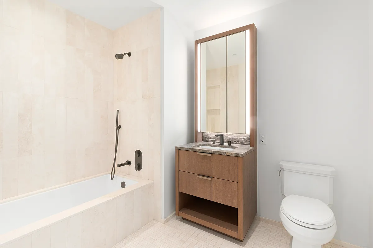 543 West 122nd Street, Unit 4B Manhattan, NY 10027 - Photo 4 of 5 a bathroom with a granite countertop toilet a sink and bathtub