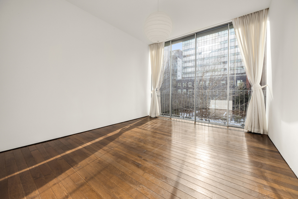 527 West 27th Street, Unit 3C Manhattan, NY 10001 - Photo 8 of 14 a view of empty room with wooden floor and fan