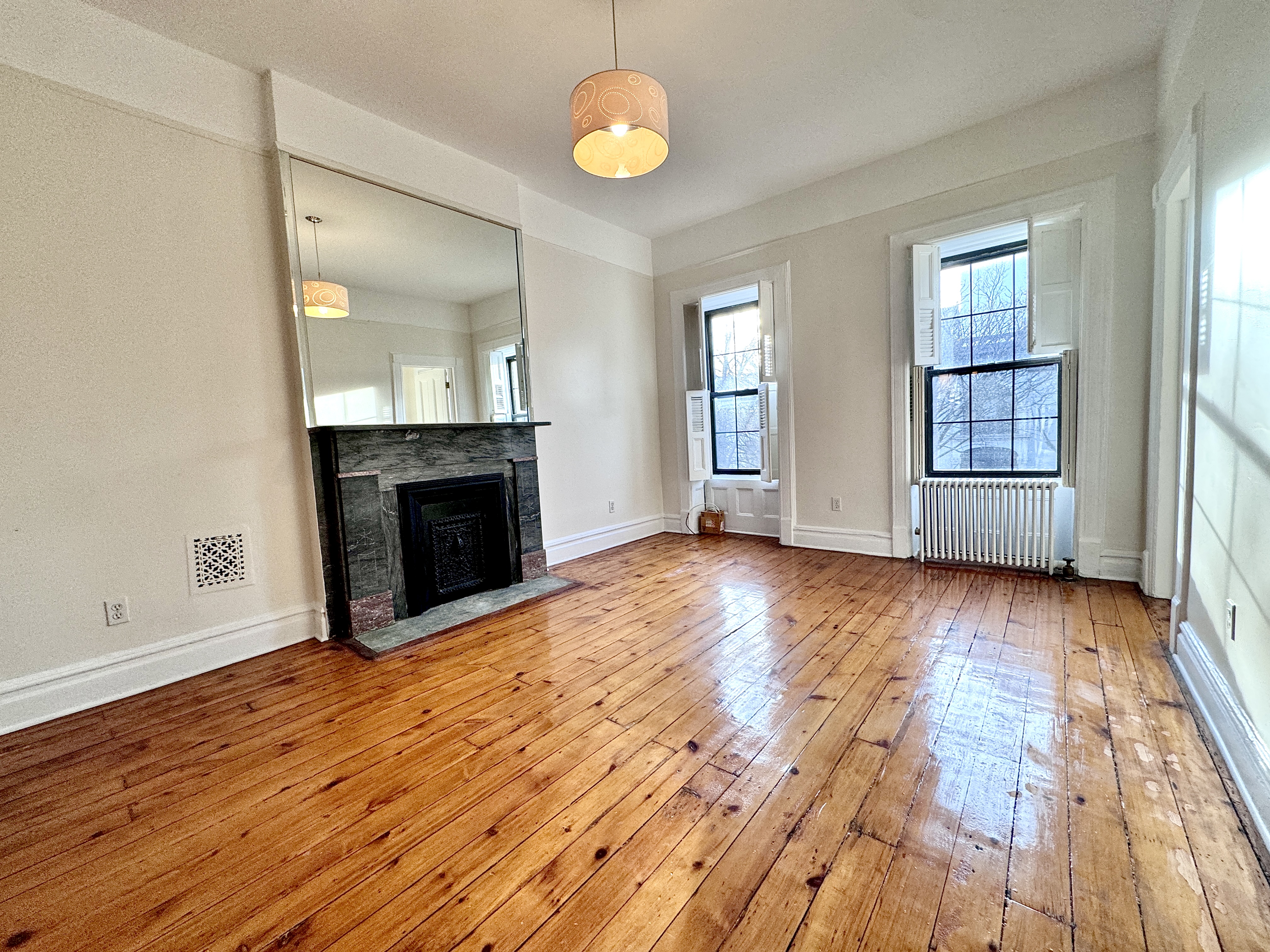 15 Arlington Place, Unit 3 Brooklyn, NY 11216 - Photo 8 of 14 an empty room with wooden floor fireplace and windows