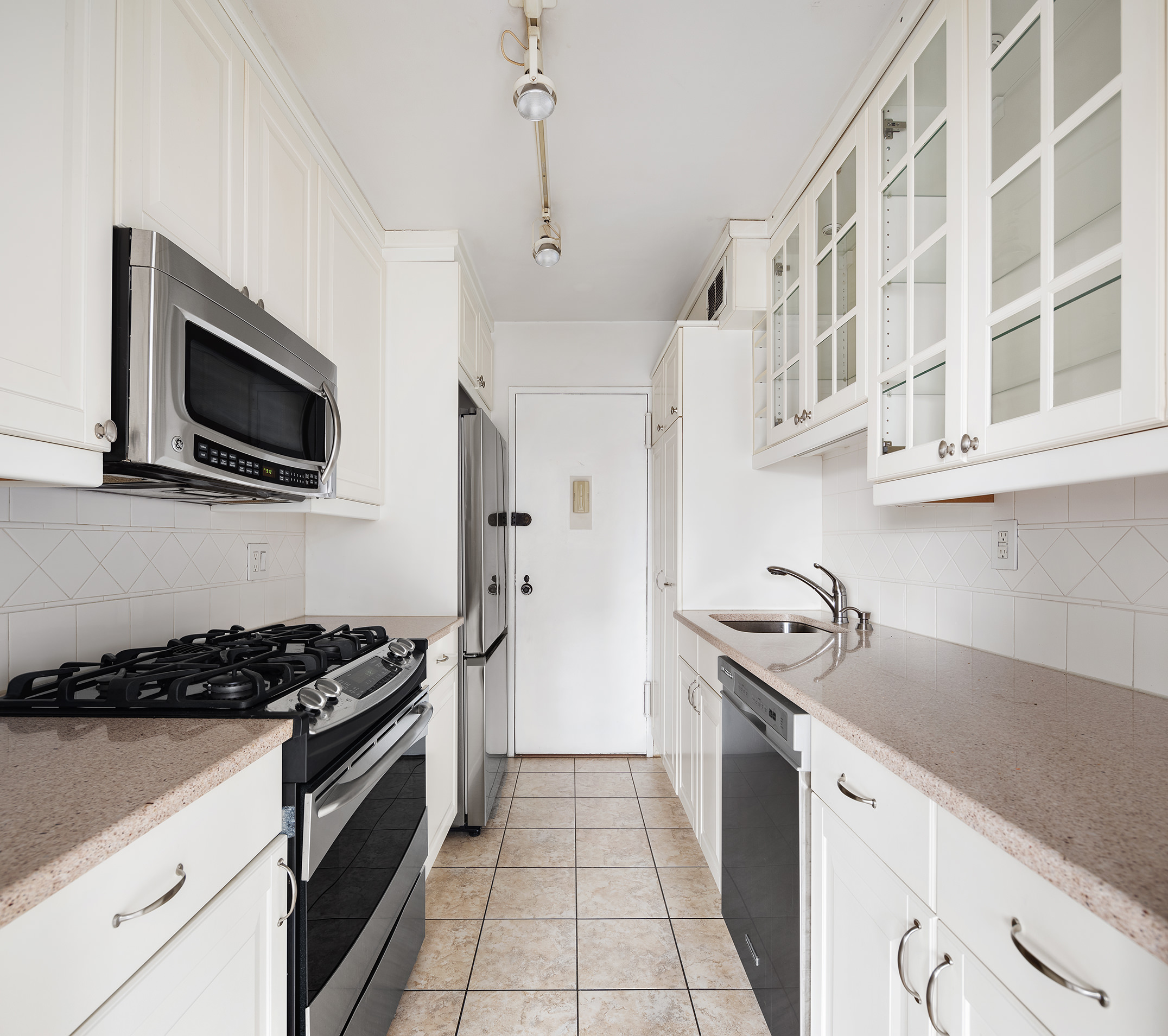 120 East 90th Street, Unit 16E Manhattan, NY 10128 - Photo 7 of 15 a kitchen with stainless steel appliances granite countertop a sink and a stove