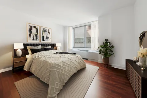 a bedroom with a large bed and a potted plant