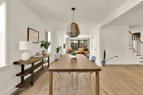 a living room with dining table and a wooden floor