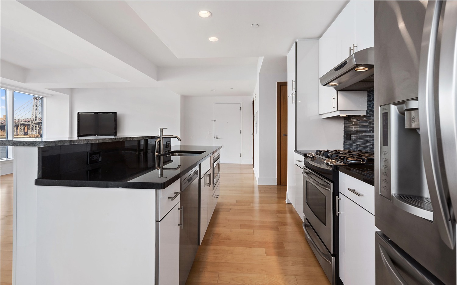 440 Kent Avenue, Unit 4A Brooklyn, NY 11249 - Photo 3 of 11 a kitchen with stainless steel appliances a sink a stove and a refrigerator