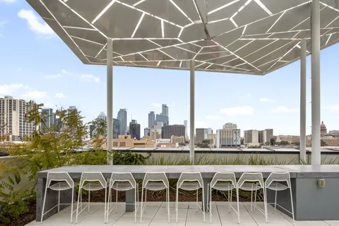 a white table sitting next to a glass top table and chairs