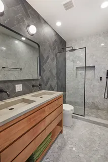 a bathroom with a double vanity sink toilet and shower