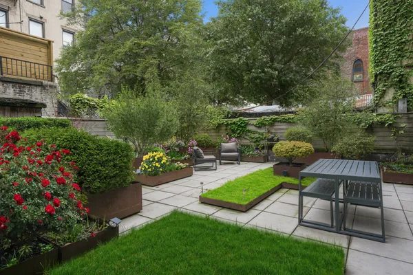 a view of a chair and table in the garden front of house