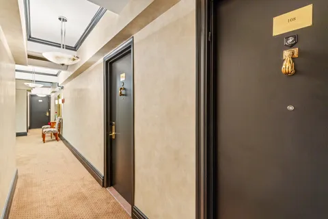 a hallway with wooden floor and stairs