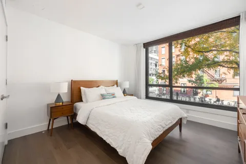 a bedroom with a bed and a large window